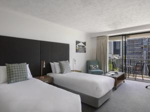 a hotel room with two beds and a balcony at Mantra Esplanade in Cairns