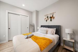 una camera da letto bianca con un letto con una coperta gialla di Soho DC Lux 1BD Apartment a Washington