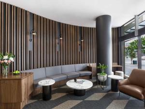 ein Wohnzimmer mit einer Couch und zwei Tischen in der Unterkunft Mantra Chatswood in Sydney
