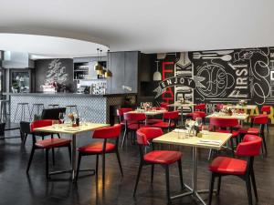 ein Restaurant mit roten Stühlen und Tischen und einer Bar in der Unterkunft Mantra Chatswood in Sydney