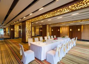 a large room with a long table and white chairs at Dolphin Hotel in Visakhapatnam