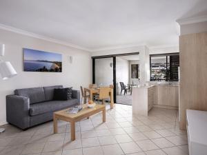 a living room with a couch and a table at Mantra Heritage in Port Douglas