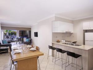 a kitchen and living room with a table and chairs at Mantra Heritage in Port Douglas