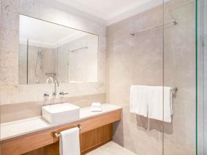 a bathroom with a sink and a shower at Mantra Heritage in Port Douglas