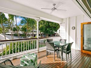 a porch with a table and chairs on a balcony at Mantra on the Inlet in Port Douglas