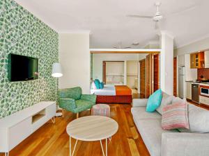 a living room with a couch and a bedroom at Mantra on the Inlet in Port Douglas