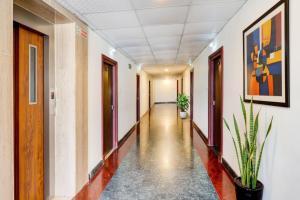 an empty corridor in an office building with plants at FabHotel Alfa in Vijayawāda