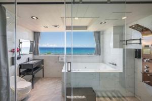 ein Badezimmer mit Badewanne und ein Fenster mit Meerblick in der Unterkunft 小琉球暮光停琉海景包棟民宿 in Xiaoliuqiu + 15 Fotos