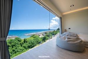 小琉球岛小琉球暮光停琉海景包棟民宿的一间卧室，有一扇大窗户，可以看到海景 更多15张照片