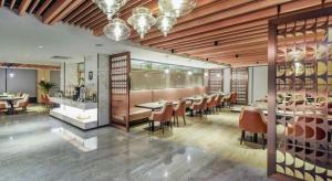 une salle à manger avec des tables et des chaises dans un restaurant dans l'établissement Lavande Hotel Nanchong Xihua Shida, à Nanchong