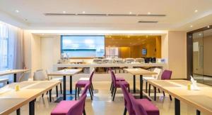 un restaurant avec des tables en bois et des chaises violettes dans l'établissement Lavande Hotel Huizhou Shiwan, à Shiwan
