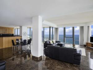 a living room with a couch and a table with chairs at Mantra Sun City in Gold Coast