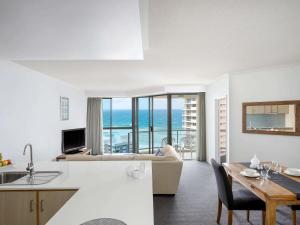 a kitchen and living room with a view of the ocean at Mantra Sun City in Gold Coast