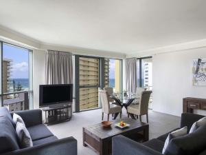 a living room with a couch and a table at Mantra Sun City in Gold Coast
