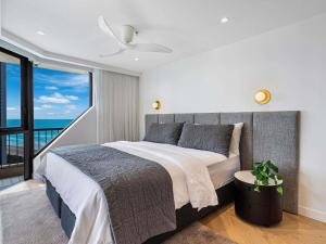 une chambre avec un grand lit avec une grande fenêtre dans l'établissement Paradise Centre Apartments, à Gold Coast 65 autres photos