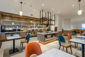 un restaurant avec des tables, des chaises et un comptoir dans l'établissement City Comfort Inn Handan New Century Plaza, à Sucao