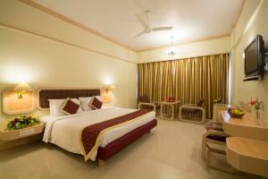 a hotel room with a large bed and a television at Dolphin Hotel in Visakhapatnam