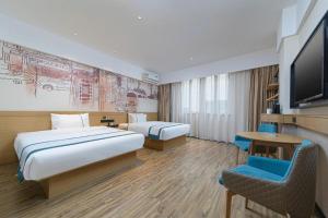 une chambre d'hôtel avec deux lits et une télévision à écran plat dans l'établissement City Comfort Inn Handan New Century Plaza, à Sucao