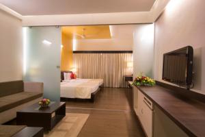 a hotel room with a bed and a television at Dolphin Hotel in Visakhapatnam