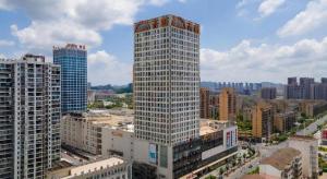 ein hohes Gebäude mitten in einer Stadt in der Unterkunft Borrman Hotel Yichun Municipal Government Ronghuicheng in Yichun