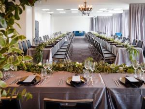 a banquet hall with long tables and chairs with flowers at Mantra Albury in Albury