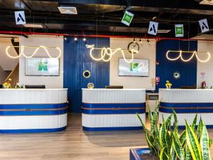 a lobby with blue and white counters and plants at Ibis Styles El Malecon Guayaquil in Guayaquil