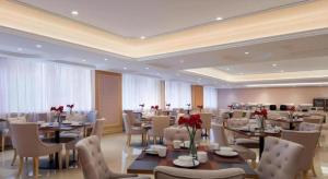 une salle à manger avec des tables et des chaises avec des roses dessus dans l'établissement Vienna Hotel Guangdong Huizhou Huabianling Square, à Huizhou