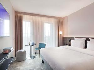 a hotel room with a bed and a table and a chair at Novotel Hamburg Central Station in Hamburg +162 photos
