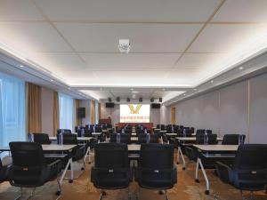 une salle de conférence avec des tables, des chaises et un écran dans l'établissement Vienna Hotel Shandong Liaocheng High-Tech Zong Yueji Park, à Liaocheng