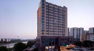 ein hohes Gebäude in einer Stadt neben einem Fluss in der Unterkunft Vienna Hotel Jiangxi Ji'an Yanjingfu in Ji'an