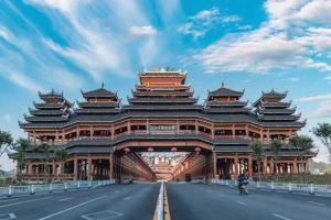 un grand bâtiment sur le côté d'une route dans l'établissement Vienna Hotel Guangxi Liuzhou Sanjiang Gulou Niaochao Passenger Station, à Sanjiang