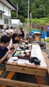a group of people sitting at a picnic table with food at Lien Tono - Vacation STAY 85593v in Tōno