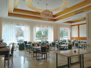 a dining room with tables and chairs and a chandelier at Vienna Hotel Hunan Shaoyang South Railway Station in Shaoyang