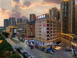 ein Gebäude mit Autos auf einem Parkplatz in einer Stadt in der Unterkunft Borrman Hotel Baise High-speed Railway Station Hengning Plaza in Qitang