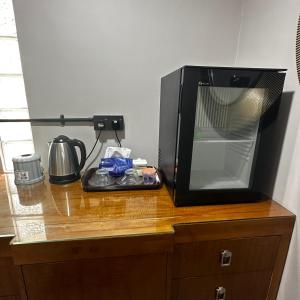 a microwave sitting on top of a wooden table at Orchid Cabin Kuala Tahan in Kuala Tahan