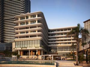 un edificio alto con una piscina di fronte di Novotel Sihanoukville Holiday Resort a Sihanoukville