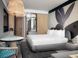 una camera da letto con un letto grande e un tavolo di Novotel Sihanoukville Holiday Resort a Sihanoukville