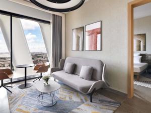 a living room with a couch and a bed at Novotel Abidjan Marcory in Abidjan