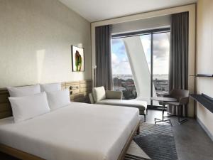 a hotel room with a large bed and a window at Novotel Abidjan Marcory in Abidjan