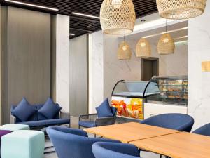 a restaurant with blue chairs and tables and a fishtank at Mercure Riyadh Al Anoud in Riyadh