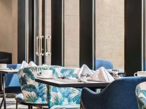 a dining room with blue chairs and a table at Mercure Riyadh Al Anoud in Riyadh +106 photos
