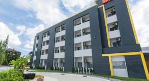 ein Apartmenthaus mit einer schwarz-weißen Fassade in der Unterkunft B2 Map Ta Phut Boutique & Budget Hotel in Ban Huai Pong