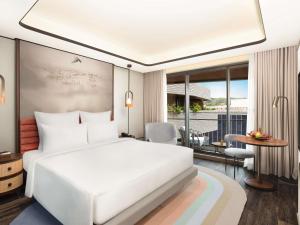 a bedroom with a large white bed and a table at Novotel Goa Panjim in Panaji +65 photos