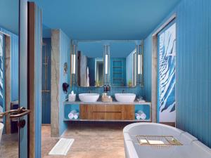 a bathroom with two sinks and a tub at Novotel Goa Panjim in Panaji