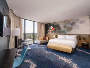 une chambre d'hôtel avec un lit, un bureau et des chaises dans l'établissement Novotel Sydney Cabramatta, à Cabramatta 86 autres photos