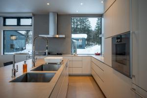 a kitchen with a sink and a large window at Mokuren by H2 Life in Niseko