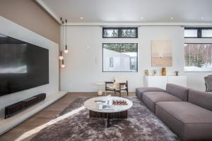 a living room with a couch and a tv at Mokuren by H2 Life in Niseko