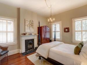 ein Schlafzimmer mit großem Bett und Kamin in der Unterkunft Luxury on Lincoln in Savannah + 46 Fotos