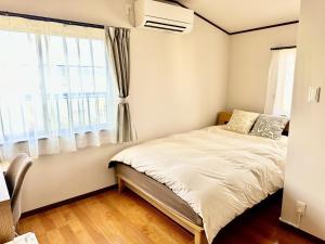 une chambre avec un lit et une fenêtre dans l'établissement 蔵の宿, à Kamogawa