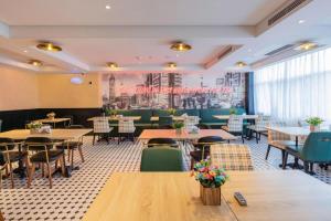 une salle à manger avec tables et chaises et un restaurant dans l'établissement City Comfort Premier Hotel Nanning Guangxi University Zoo Metro Station, à Nanning